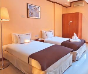 班昌SCN City Hotel Rayong的酒店客房,设有两张床和一盏灯