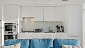 华盛顿Pure Voyage Shaw的厨房配有白色橱柜和蓝色椅子