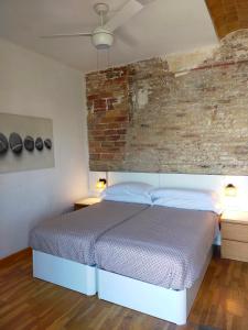巴塞罗那Barceloneta Port Ramblas的一间卧室设有一张床和砖墙