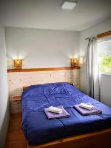 埃博森BALCON CORDILLERANO的一间卧室配有蓝色的床和2条毛巾