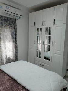 达喀尔Dakar Creek的卧室配有白色橱柜和白色床。