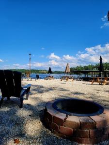 奥沙克湖Lakeshore Fishing Cabin 5, dock, boat slip and firepit area的海滩上的火坑和椅子