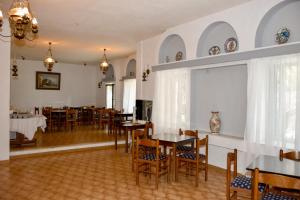 斯科拉Anamar Patmos的用餐室设有桌椅和窗户。