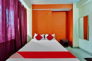 巴特那OYO Flagship Hotel CDS Regency的一间卧室设有红色和橙色墙壁的床