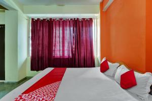 巴特那OYO Flagship Hotel CDS Regency的一间卧室设有一张红色墙壁和窗户的床
