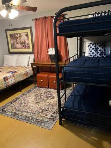 孟菲斯Chic Rancher 7BR Compound Near Graceland & Airport的客房设有两张双层床和一张书桌。
