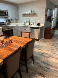 孟菲斯Chic Rancher 7BR Compound Near Graceland & Airport的厨房铺有木地板,配有木桌。
