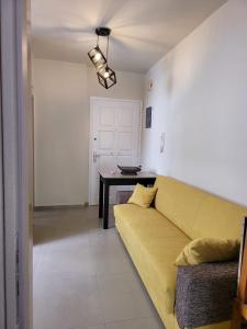 拉斐那Stephie's apartment by the sea的客厅配有黄色的沙发和桌子