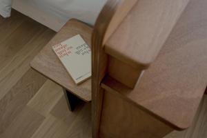 比亚里茨ALFRED HOTELS Les Halles - Ex Hotel Anjou的坐在木凳上看的书