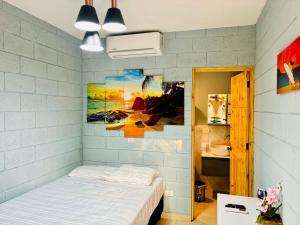 TamaniqueHostal Camila’s的卧室配有一张床,墙上挂有绘画作品