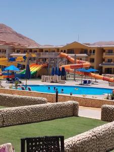 艾因苏赫纳Porto El Sokhna Aqua park的度假村内带水滑梯的游泳池