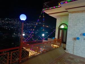 穆扎法拉巴德SEE MOTEL的阳台享有夜间城市美景。