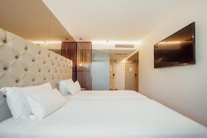 波尔图波尔图ABC酒店 - 博阿维斯塔 的一间卧室设有两张床,墙上配有电视。