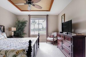 瓦克拉Five Star Waikoloa Beach Villa, Golf & Lake Views的一间卧室配有一张床和一台平面电视