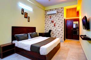 加济阿巴德Collection O Hotel Liv Inn的一间卧室配有一张大床和电视