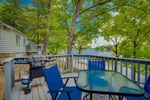 奥沙克湖Lakeshore Cabin 2 dock, boat slip and patio的房屋甲板上的烧烤架和椅子