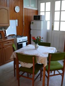 小克勒什Madácsi Vendégház的厨房配有桌子和白色冰箱。