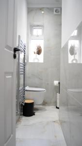 East BarnetOakleigh House, 3 bedroom, free parking的白色的浴室设有浴缸和窗户。