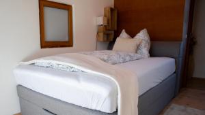 因斯布鲁克Eva Apartments - Nordkette的一间卧室配有一张带白色床单的床和一扇窗户。