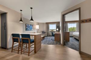 河边城Candlewood Suites Aberdeen-Bel Air, an IHG Hotel的一间带桌椅的房间和一间卧室