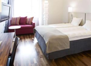 哥德堡斯堪迪克皇冠酒店的一间卧室配有一张大床和一张沙发