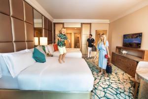 迪拜棕榈岛亚特兰蒂斯酒店的站在酒店房间床上的小女孩