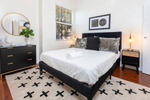 洛杉矶Sleek & Upscale: Premier 1-BR Apartment in LA!的一间卧室配有一张床、梳妆台和镜子