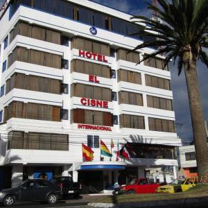 里奥班巴Hotel El Cisne Internacional的门前有车辆停放的酒店