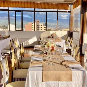 里奥班巴Hotel El Cisne Internacional的用餐室设有长桌子、椅子和窗户。