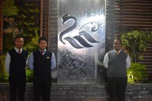 里奥班巴Hotel El Cisne Internacional的站在标志前的三人小组