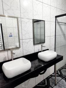 瓜鲁柳斯AEROHOSTEL Brasil的浴室设有2个盥洗盆和镜子,位于柜台上