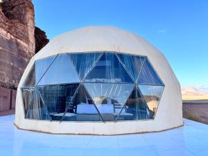 瓦迪拉姆Desert heart camp的沙漠中带玻璃窗的圆顶房屋