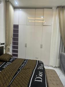 IranlaTwo bedroom duplex in Chevron Lekki phase 2的一间卧室配有一张床和白色橱柜