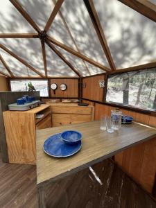 Los LiriosGlamping en la Sierra de Arteaga的厨房里设有一张桌子,上面有蓝色的盘子
