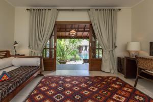 克罗柏坎Villa Balidamai by Nagisa Bali的一间卧室设有一张床,并有通往庭院的门
