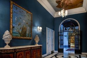 马德里雷蒂罗帕里西奥酒店，傲途格精选的走廊上设有蓝色的墙壁,配有绘画和镜子