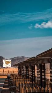 DisahV D C Wadi Rum的沙漠中一座带椅子和标志的建筑