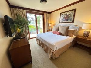 卡波雷Luxury Ko Olina Beach Rental B105 Ground floor with Private Garden 1parking的一间卧室配有一张大床和电视