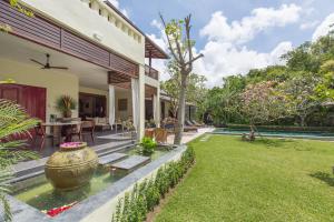 克罗柏坎Villa Balidamai by Nagisa Bali的一座带锦 ⁇ 池塘的房屋的后院