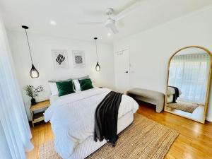 TootgarookCosy Beach House - Near Hot Springs.的一间卧室配有一张大床和镜子