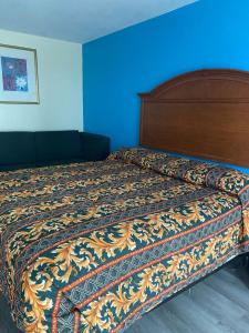 什里夫波特Clover Inn and Suites的卧室内的一张床铺,卧室内有蓝色的墙壁