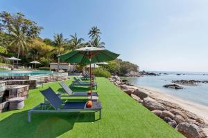 拉迈ShaSa Resort - Luxury Beachfront Suites的游泳池旁的一排躺椅和遮阳伞