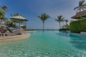 拉迈ShaSa Resort - Luxury Beachfront Suites的棕榈树度假村的游泳池