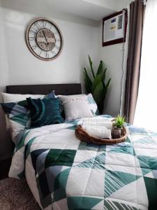 大雅台PY Suites Tagaytay的卧室配有一张挂在墙上的带时钟的床