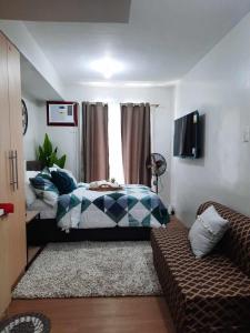 大雅台PY Suites Tagaytay的一间卧室配有一张床和一张沙发