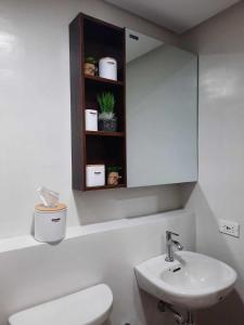 大雅台PY Suites Tagaytay的一间带水槽、卫生间和镜子的浴室
