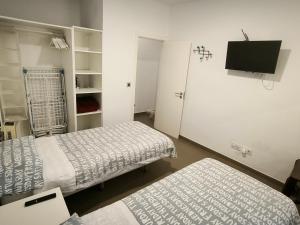 大加那利岛拉斯帕尔马斯Turina House - 3 habitaciones的客房设有两张床和一台平面电视。