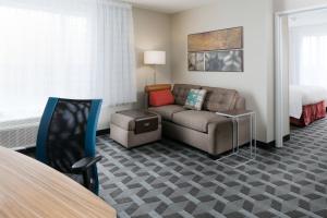 堪萨斯城TownePlace Suites by Marriott Kansas City Airport的酒店客房设有一张沙发和一张床