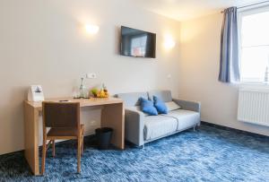 弗伦斯堡峡湾酒店的客厅配有沙发、桌子和书桌