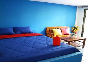 Ban Don KlangPRAKAI RESORT的蓝色卧室,配有床和桌子